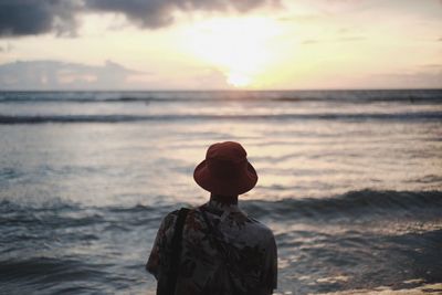 Rear view of man wearing hat while looking at sea