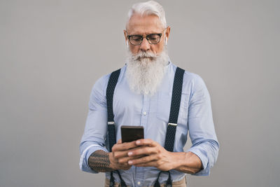 Man using phone against gray background