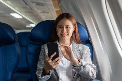 Young woman using mobile phone while sitting in car