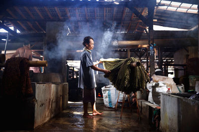 Rear view of man standing in factory