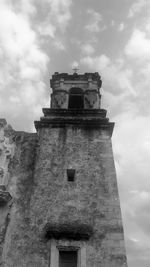 Low angle view of bell tower against cloudy sky