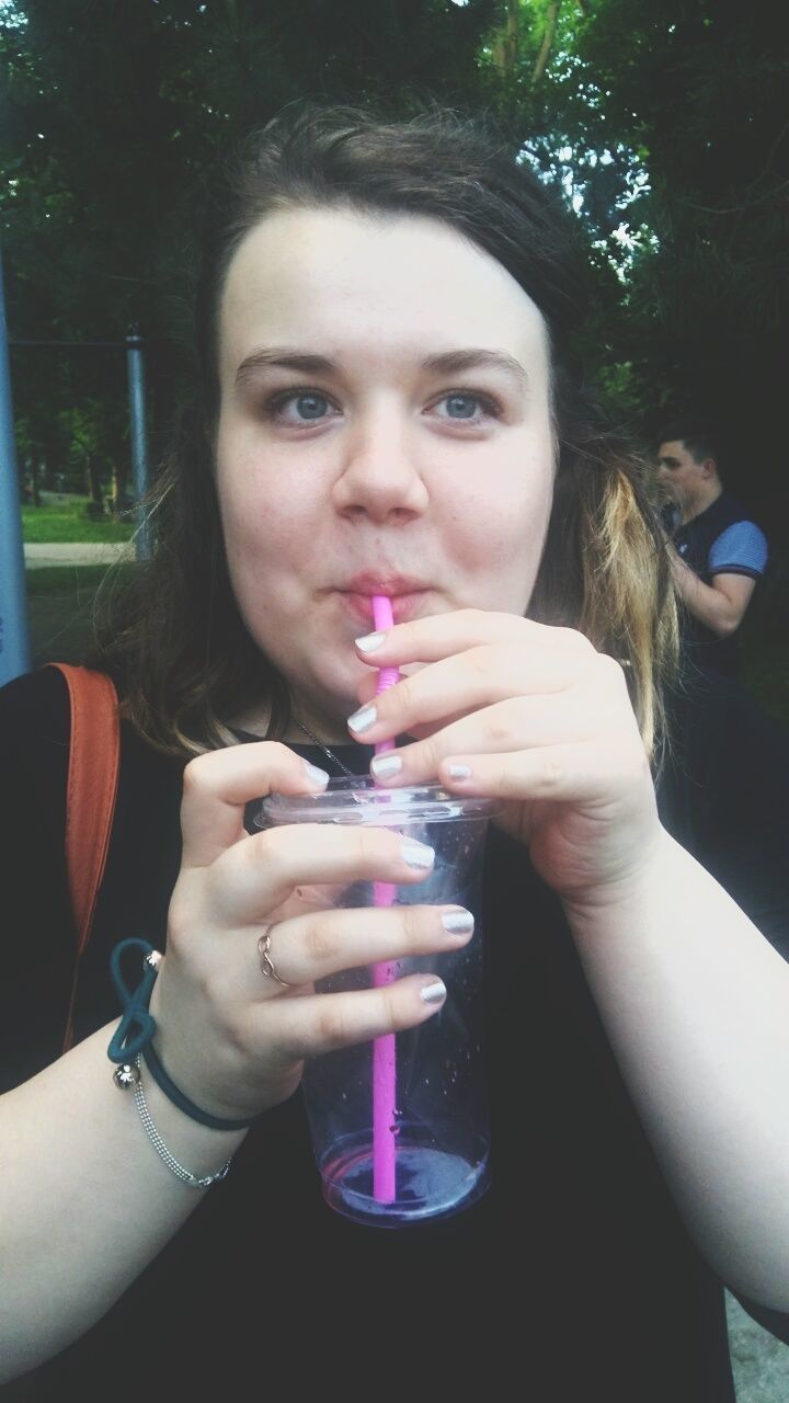 CLOSE-UP PORTRAIT OF BEAUTIFUL YOUNG WOMAN WITH DRINK