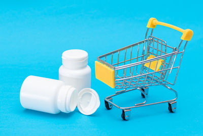 Close-up of toy shopping cart against blue background