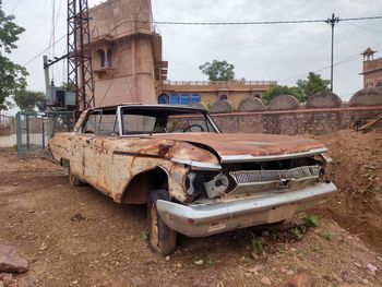 Old abandoned car against sky