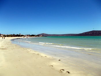 Scenic view of beach against blue sky