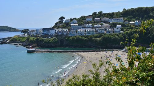 Buildings by sea against sky