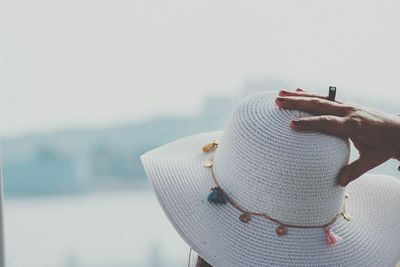 Close-up of woman touching her hat outdoors