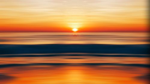 Scenic view of sea against romantic sky at sunset