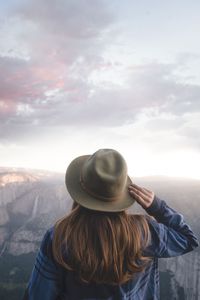 Rear view of woman in hat against sky