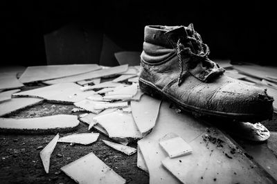 Close-up of shoe on broken glass