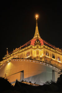 Low angle view of illuminated buildings against sky at night