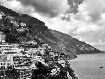 Scenic view of town by sea against sky