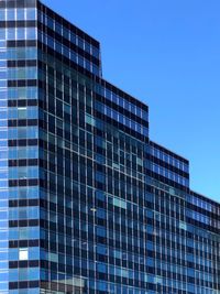 Low angle view of modern building against clear blue sky