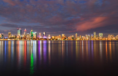 Illuminated buildings against sky at night