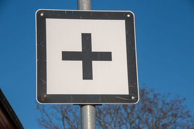 Low angle view of road sign against blue sky