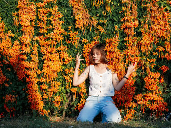 Smiling girl standing by plants during autumn