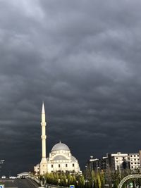 Buildings in city against cloudy sky