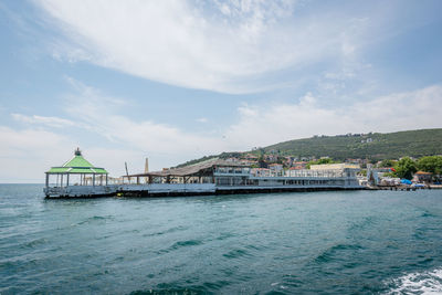 Scenic view of sea by buildings against sky