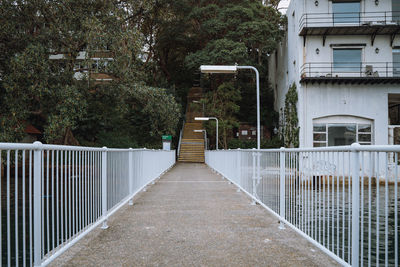 Empty footpath amidst buildings in city