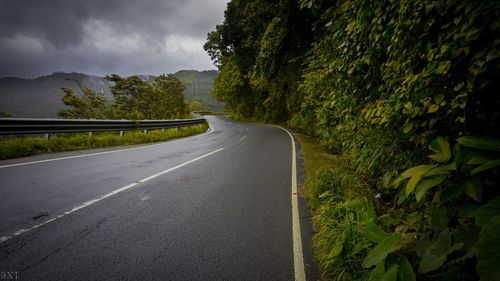 Road amidst trees against sky