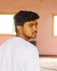 Portrait of young man looking away at home