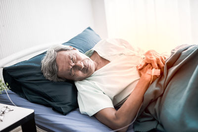 Midsection of man sleeping on bed