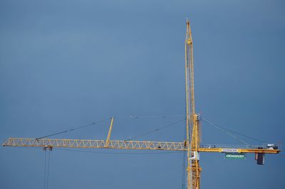 Low angle view of crane against sky