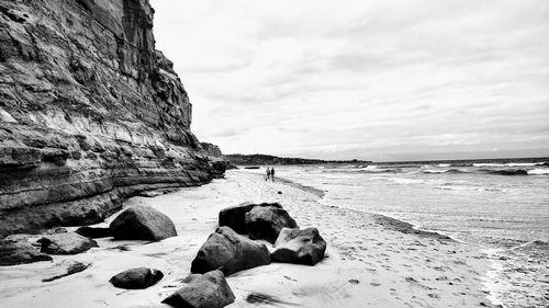 Rocks on beach against sky