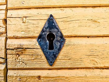 Iron keyhole in a yellow wall