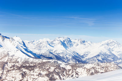 Scenic view of snowcapped mountains against blue sky