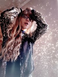 Low angle portrait of fashionable young woman standing at home