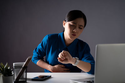 Young man using mobile phone while sitting on table