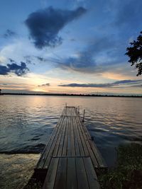 Pier over lake against sky during sunset