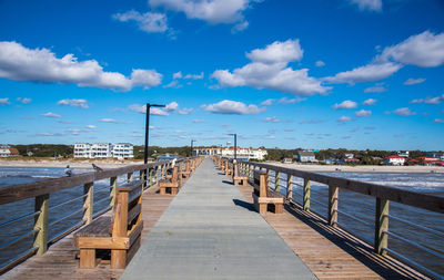 Empty pier on sea against sky