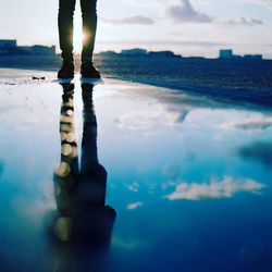 Low section of man with reflection in water