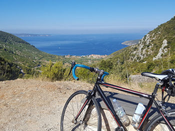 Bicycle on mountain against blue sky