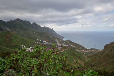 Scenic view of sea and mountains against sky