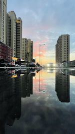 Digital composite image of buildings against sky during sunset