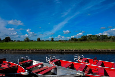 View of boats moored in lake against blue sky