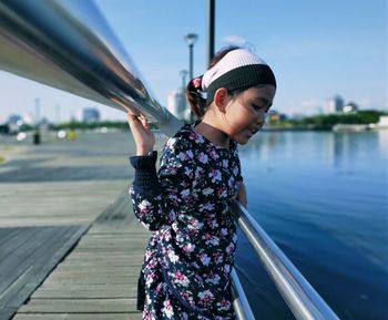 Young woman standing by railing