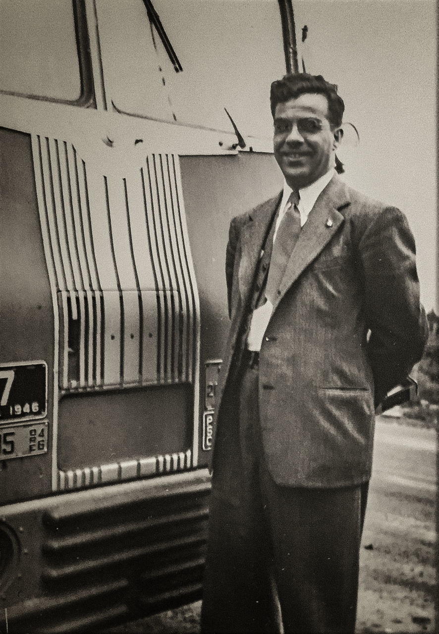 PORTRAIT OF YOUNG MAN STANDING AGAINST BLURRED BACKGROUND