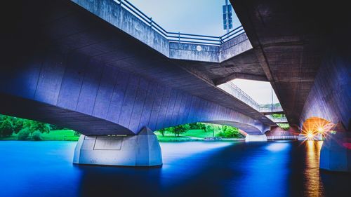 Illuminated bridge over river against sky