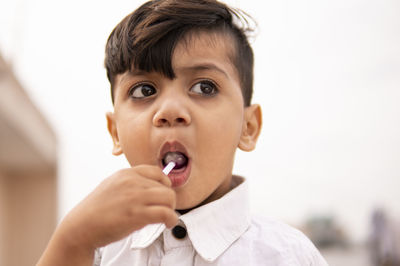 Close-up portrait of boy holding camera