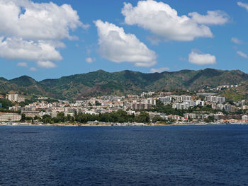 View of townscape by sea against sky
