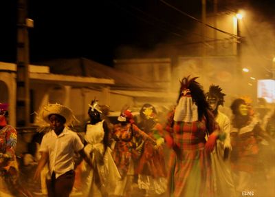 Group of people in illuminated street at night