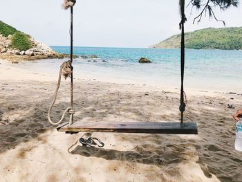 View of swing on beach against sky