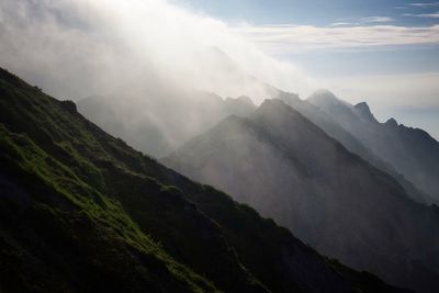 Scenic view of mountains against cloudy sky