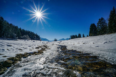 Scenic view of snowcapped mountains against bright sun