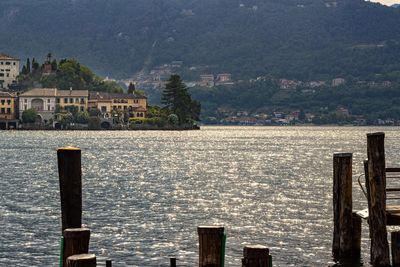 Scenic view of lake by buildings against mountain