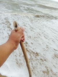 Cropped hand of man working at beach